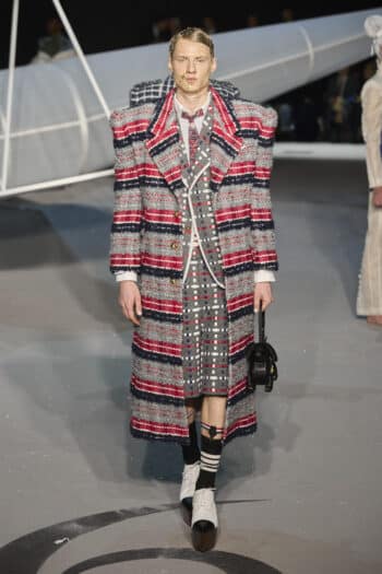 Thom Browne NYFW 2023: oversized padded shoulders midi coat in red and grey tweed